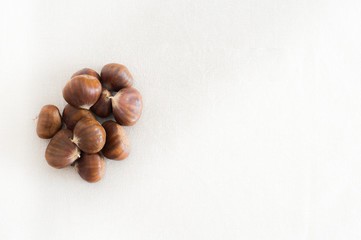 Raw whole brown chestnuts heap