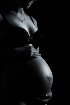 Schwangerschaftsbauch einer jungen Frau im Seitenlicht