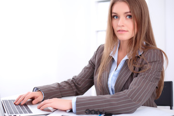 young business woman sitting at the desk on office background