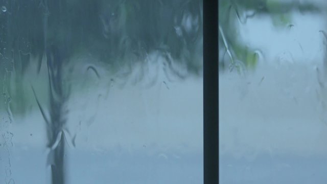 Rain water hitting house windows during thunderstorm