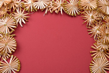 Obraz premium Christmas background with golden straw stars on a red background