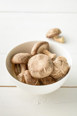 Mushrooms in a ceramic bowl on wood table, Still life with mushr