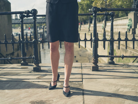 Legs of young businesswoman in city