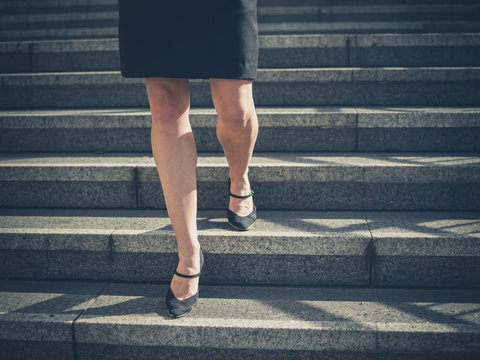 Legs of young businesswoman in city on stairs