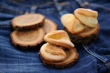 Homemade puff cookies on wooden stands on old jeans selective fo