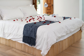 hotel room bed with scattered rose petals