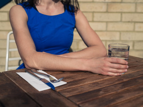 Young woman sitting at table outside restaurant