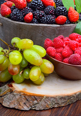 Blackberries, strawberry, raspberry and grapes in a wooden