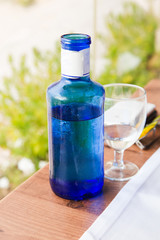 Glass and bottle at place setting on restaurant dining table