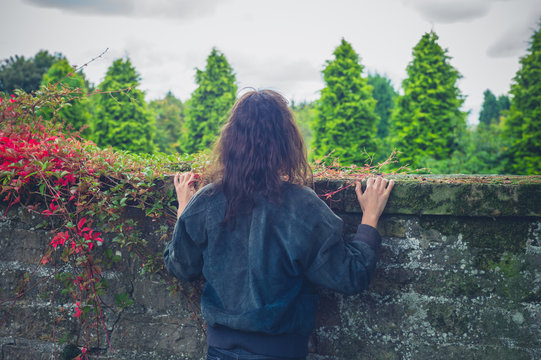 Young woman looking over wall