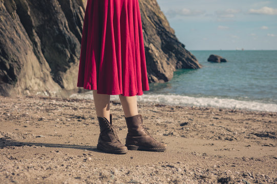 Woman in dress and boots on beach
