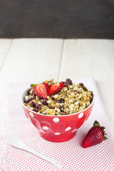 Granola with strawberry on a white wooden background
