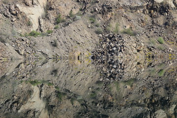 Reflection of rocks in blue lake