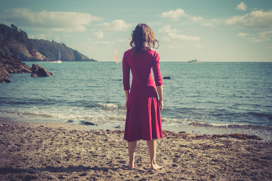 Woman in red dress on a beach
