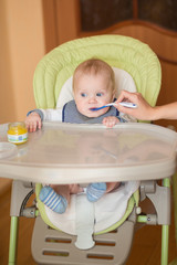 babyboy eating in high chair