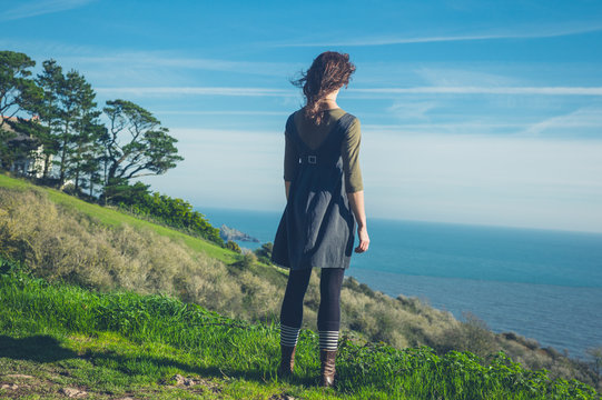 Young woman on hilltop by the sea