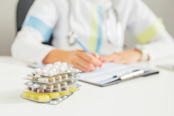Doctor writing a prescription to pills 