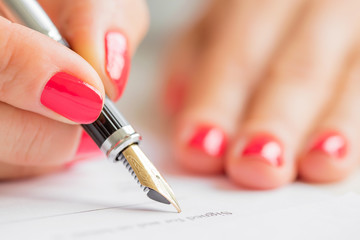 Close up of woman signing contract 