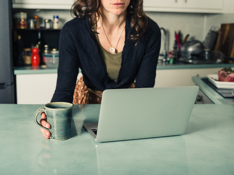 Young woman using laptop in kitchen