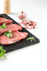 Raw beef steak with peppers and herbs