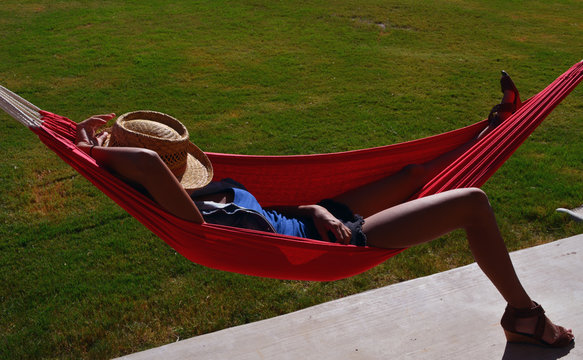 Hammock Foot Down/ Tan lady laying on hammock with her foot on the ground