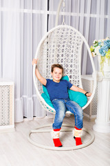 little boy sitting on white chair