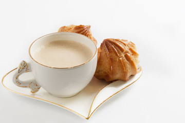 Coffee in a white cup and eclairs with cream on a white background