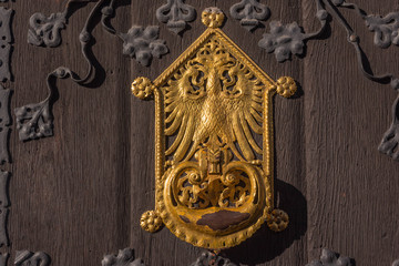 Goldenes Wappen auf Holztüre