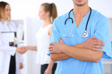 Unknown  male surgeon doctor  with stethoscope, crossed arms