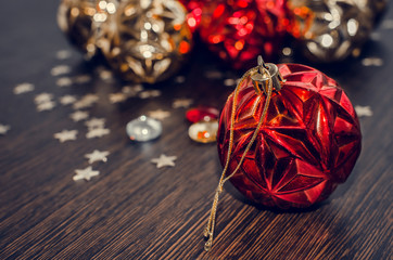 Red christmas ball on bokeh background of xmas ornaments. Merry christmas. Winter holidays. Xmas theme. Happy New Year. Blurred background.