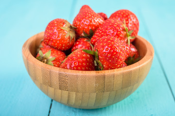 Strawberry Wood Bowl On Blue Boards Background