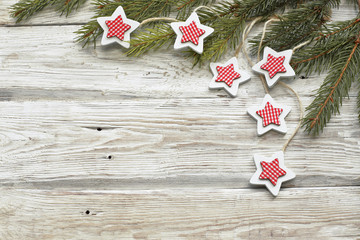 stars on wooden white with christmas tree branch  background