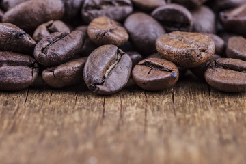 coffee grains on grunge wooden background closeup