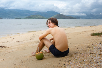 Fototapeta na wymiar Young man relaxing on a beach in Asia.