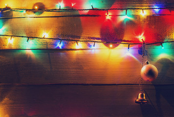 Christmas lights and globes on wood background