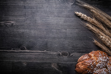 Composition of bread wheat and rye ears on wooden board