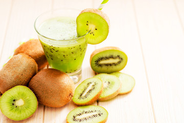 Fruit smoothie with fresh green kiwi on a wooden background