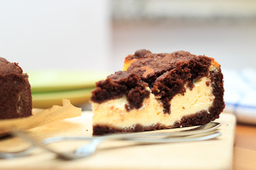 Cheesecake with chocolate shortcrust pastry and chocolate crumble arranged on a wooden board