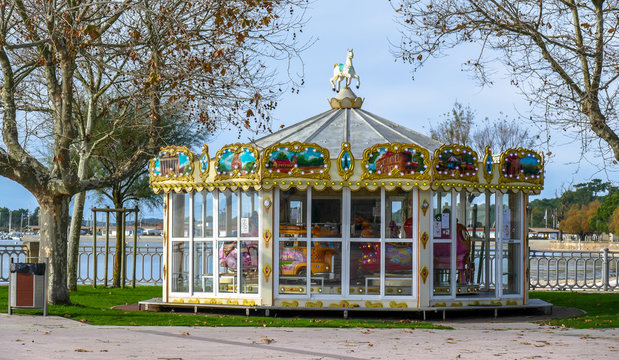 French colorful carousel in the park with wooden horses