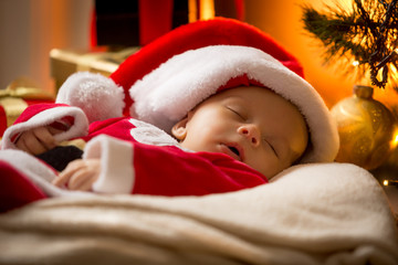 portrait of sleeping baby boy in Santa cap at living room