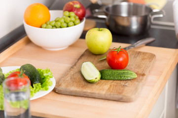 Closeup of fresh vegetables and fruits lying on wooden board at