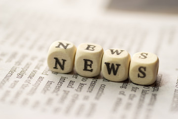 Wooden blocks with the text, NEWS, on the newspaper