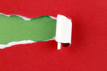 Ripped red paper on green. Christmas background