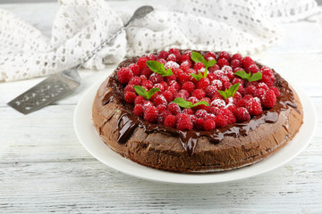 Cake with Chocolate Glaze and raspberries on color wooden background