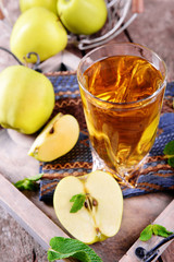 Glass of apple juice with fruits and fresh mint on table close up