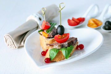 Tasty canapes on wooden table, close up