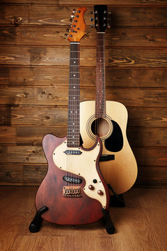 Electric and acoustic guitars on wooden background