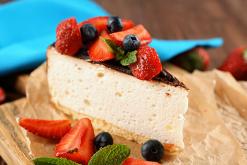 Delicious cheesecake with berries on table close up