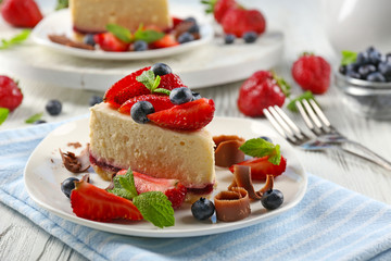 Delicious cheesecake with berries on table close up