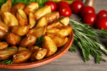 Baked potato wedges on wooden table, closeup